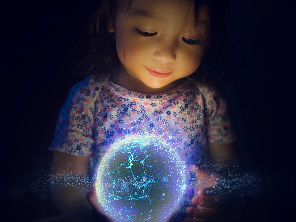 Image of a girl looking at a glowing atom ball