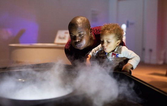 Father and son blowing smoke with dry ice